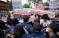 Protesters hold signs during a outside of a building which houses Japanese Embassy, in Seoul, South Korea, 24,08,2023.