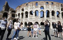 Tourists wear face masks to curb the spread of COVID-19 as they listen to a tour guide outside the ancient Colosseum, in Rome, May 21, 2021. 