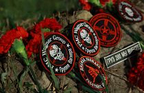 Flowers and patches bearing the logo of private mercenary group Wagner are seen at the makeshift memorial in front of the "PMC Wagner Centre" in Saint Petersburg, 24 August 