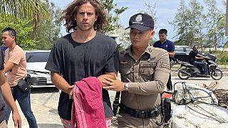 A Thai police officer escorts Spanish Daniel Sancho Bronchalo on suspicion of murdering and dismembering a Colombian surgeon from Koh Phagnan island to Koh Samui Island court.