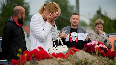 A woman reacts at an informal memorial next to the former 'PMC Wagner Centre' in St. Petersburg, Russia, Thursday, Aug. 24, 2023. 