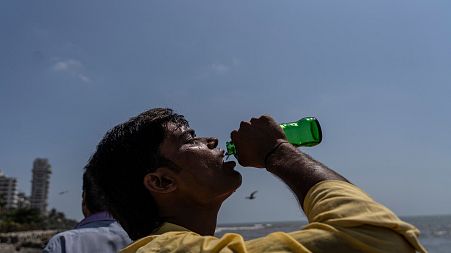 A boy drinks soda at a promenade on the Arabian Sea coast in Mumbai, India.